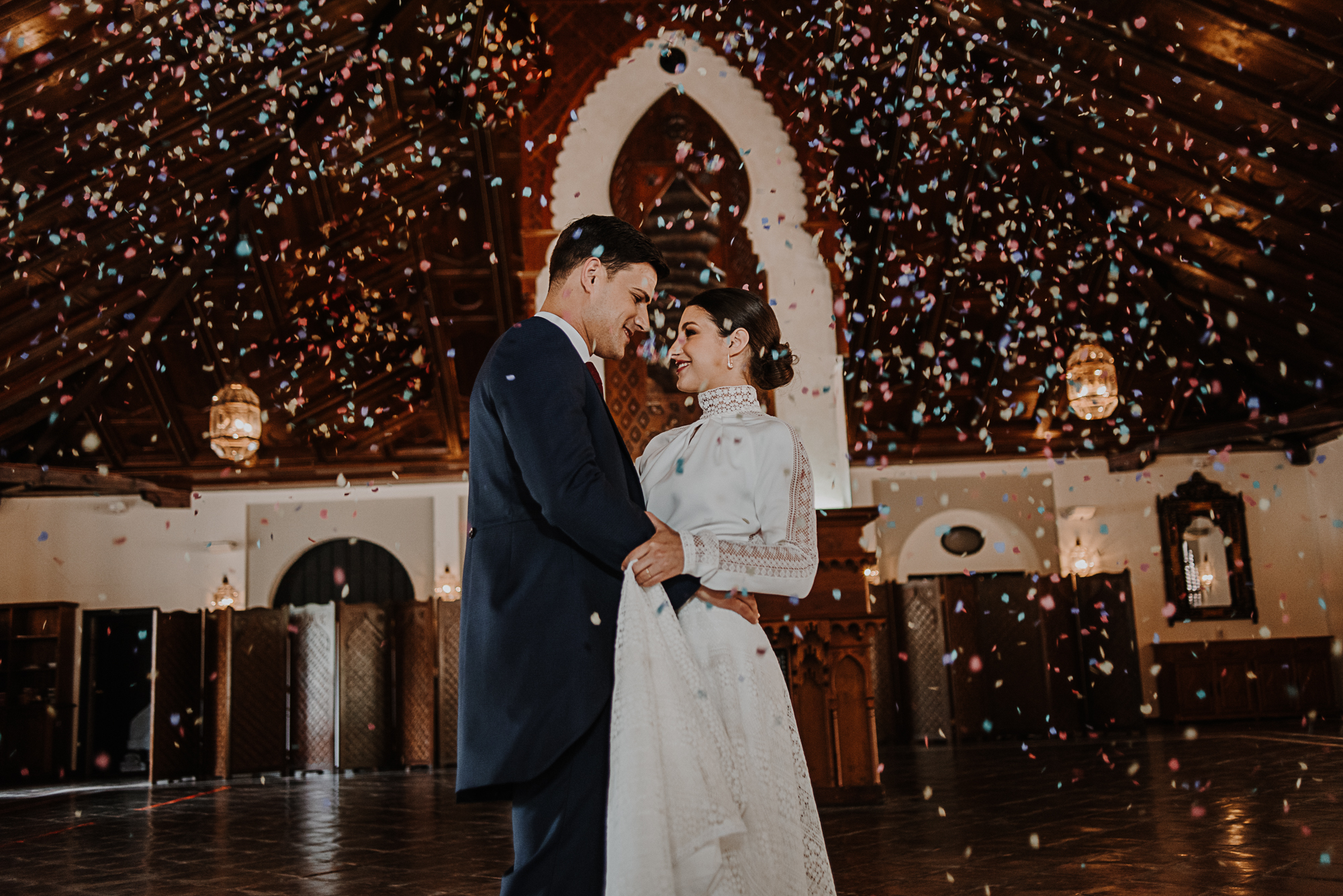 Pareja de recién casados bailando bajo una lluvia de confeti