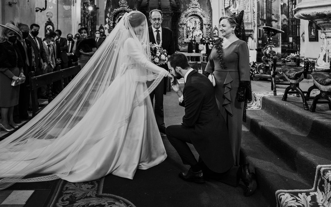 Pablo arrodillado besándo la mano a María a los pies del altar de la Parroquia de la Magdalena de Sevilla, justo antes de casarse.