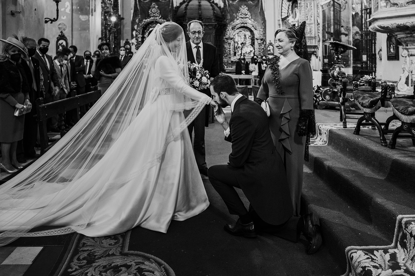 Pablo arrodillado besándo la mano a María a los pies del altar de la Parroquia de la Magdalena de Sevilla, justo antes de casarse.